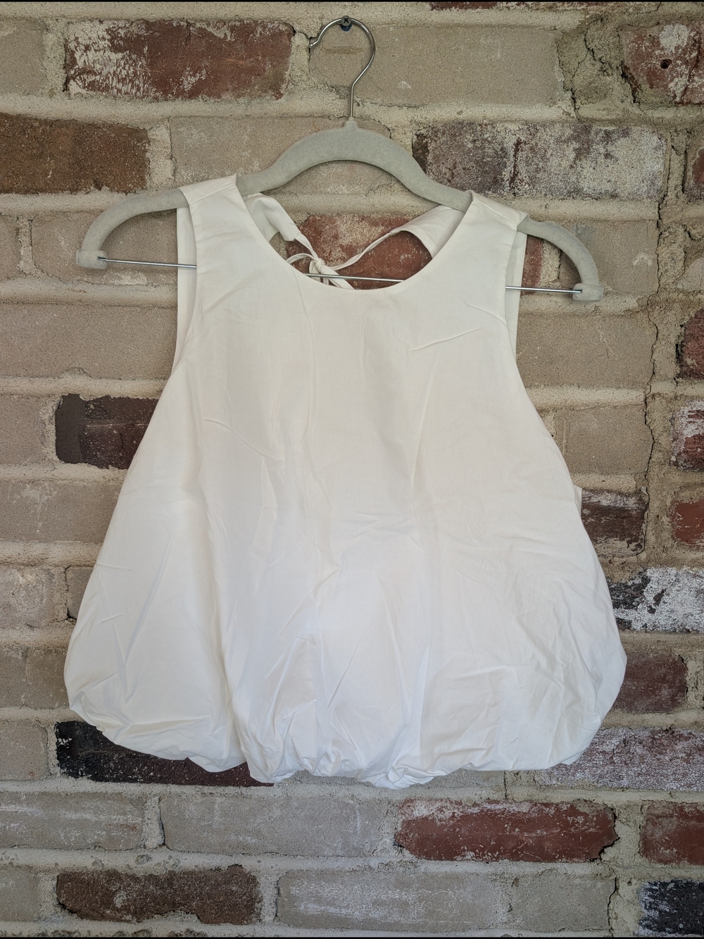 Sleeveless White Bubble-Hem Blouse with Tie-Back
